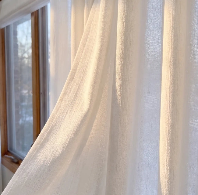 Sheer white curtain in front of a window with natural light