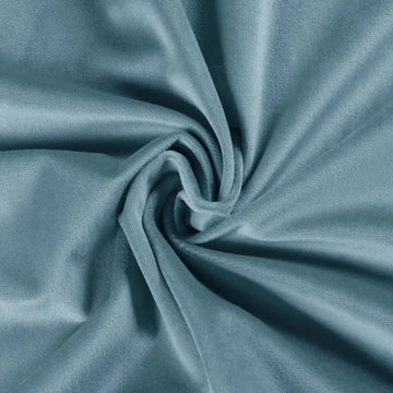 Photograph of soft light blue teal velvet fabric draped in a swirling spiral pattern showcasing plush folds and subtle highlights