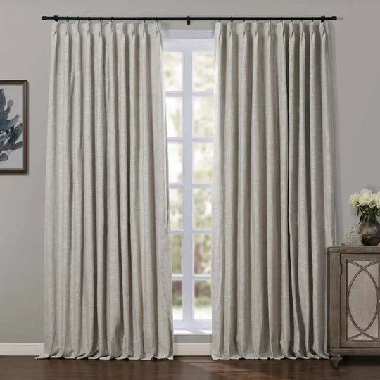 Window featuring light greige textured linen blackout curtains on a black rod, a rustic wooden cabinet with mirrored doors, and a framed abstract blue artwork