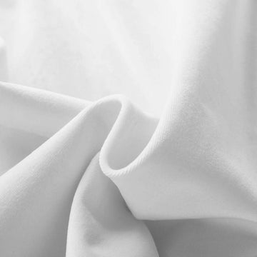 Photograph of plush white fabric with flowing soft folds and subtle shadows defining its smooth texture